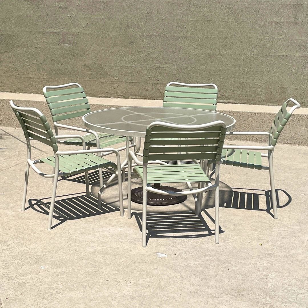 Commercial patio furniture set with green katana strap chairs and acrylic table at hoa or hotel patio. Furniture restored by Patio Guys.