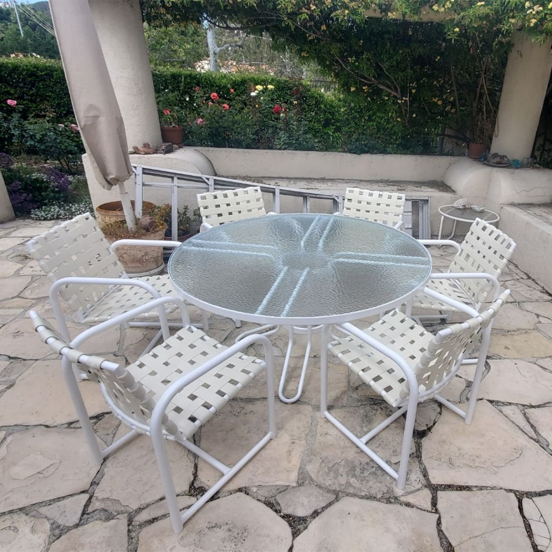 newly restored patio set featuring a new custom cut acrylic outdoor table top in white round patio table surrounded by vinyl strap chairs - patio guys