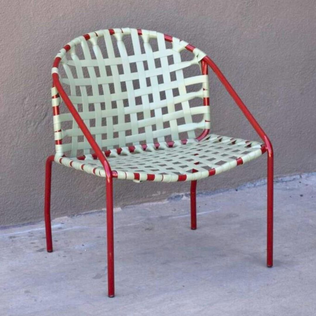 Unique red outdoor chair with a curved back and green lido vinyl strapping repainted and restrapped by patio guys.