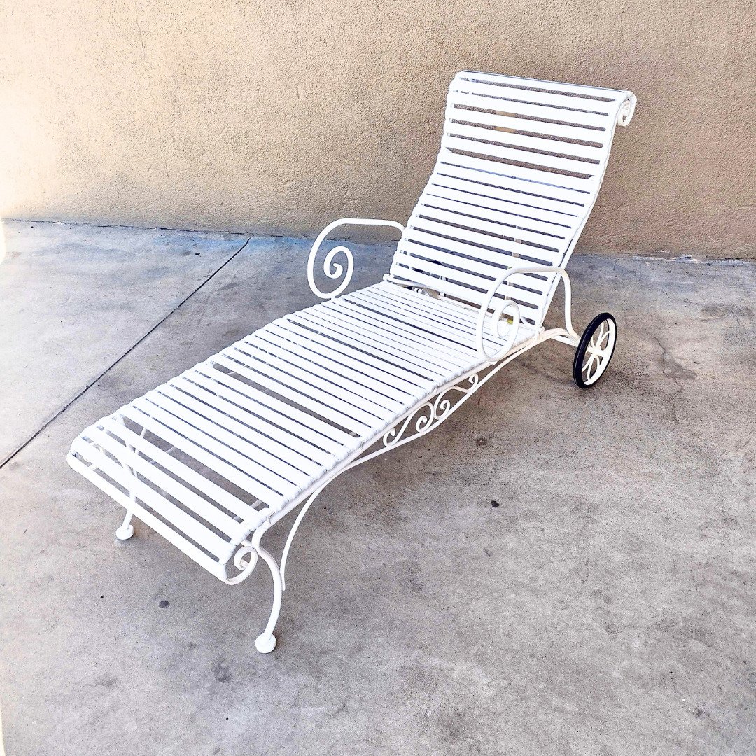 Ornate vintage white chaise lounge with vinyl strap and black wheels. Restored by Patio Guys