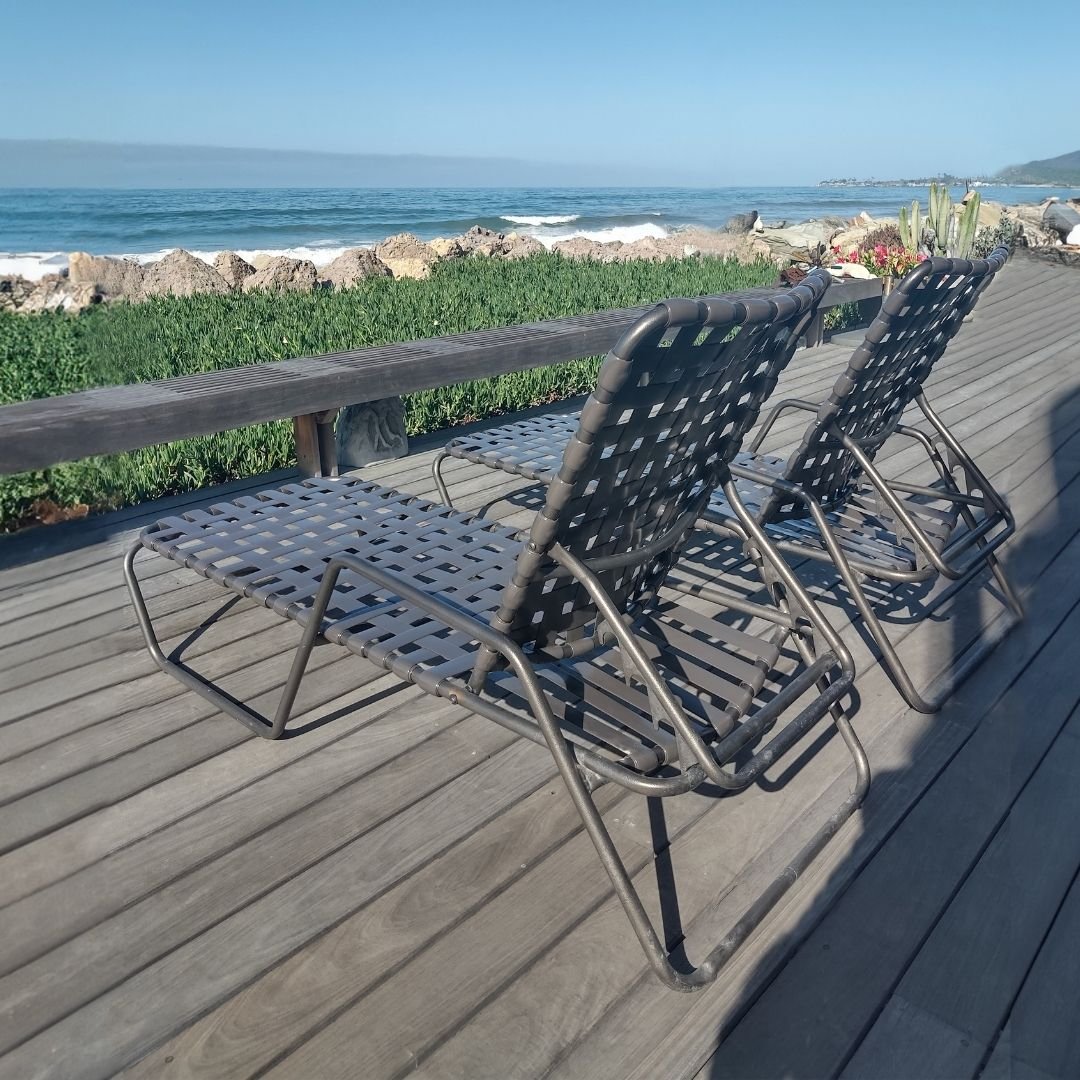 outdoor patio chaise lounges with brown powder coat and strap on ocean view deck