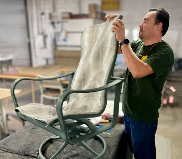 Patio Guys technician replacing the sling on a Brown Jordan swivel patio chair